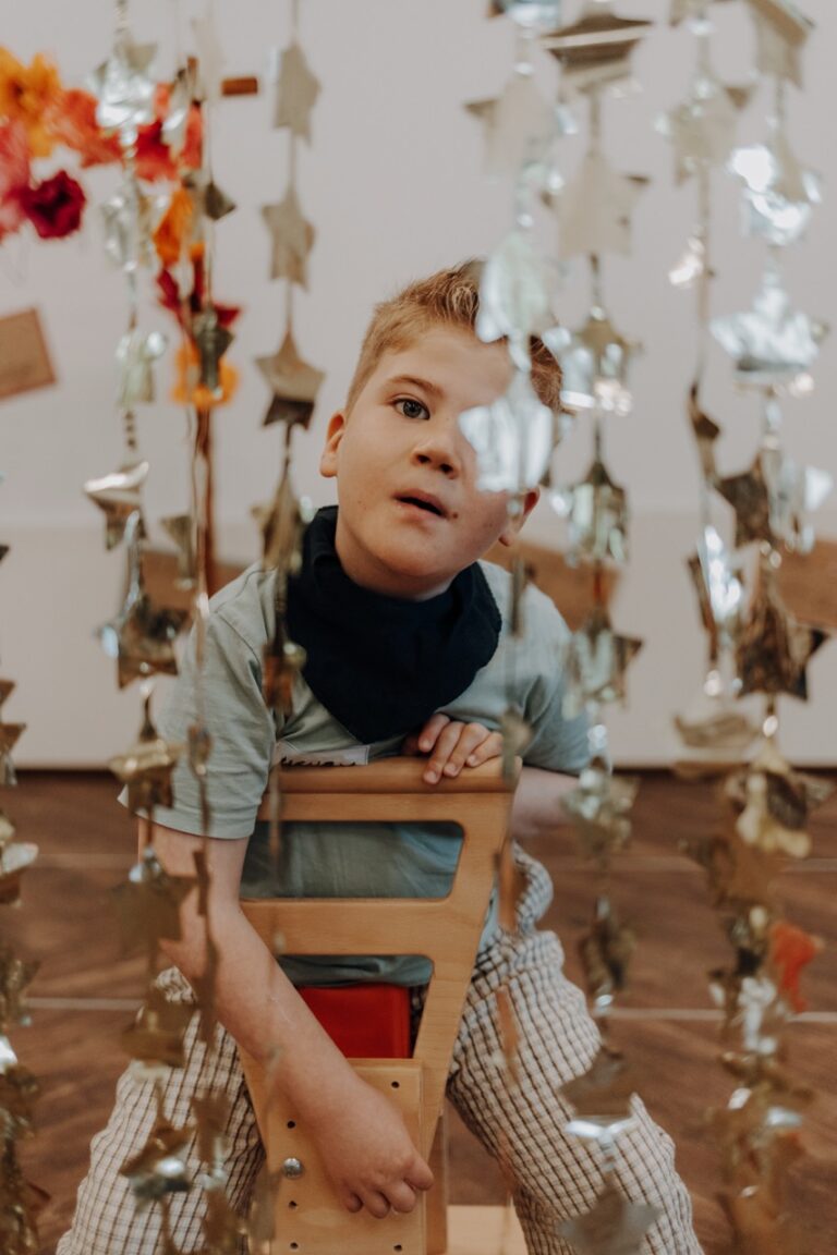 Ein Bub auf einem Holzwägelchen