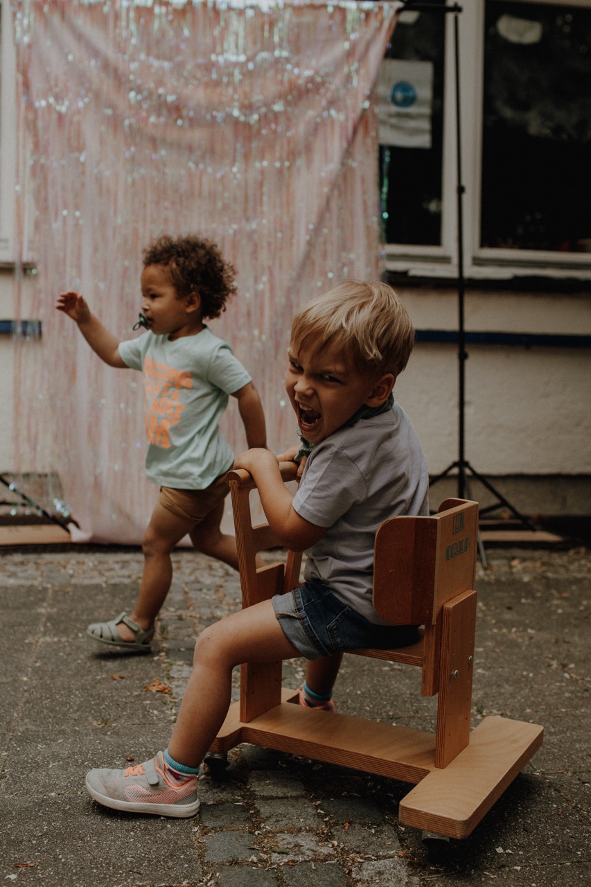 Leon auf seinem Holzwägelchen mit einer großen Freude
