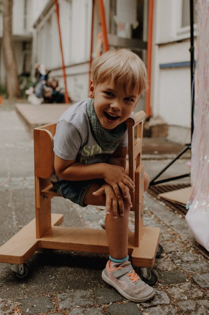 Leon auf seinem Holzwägelchen. Er freut sich wie immer.
