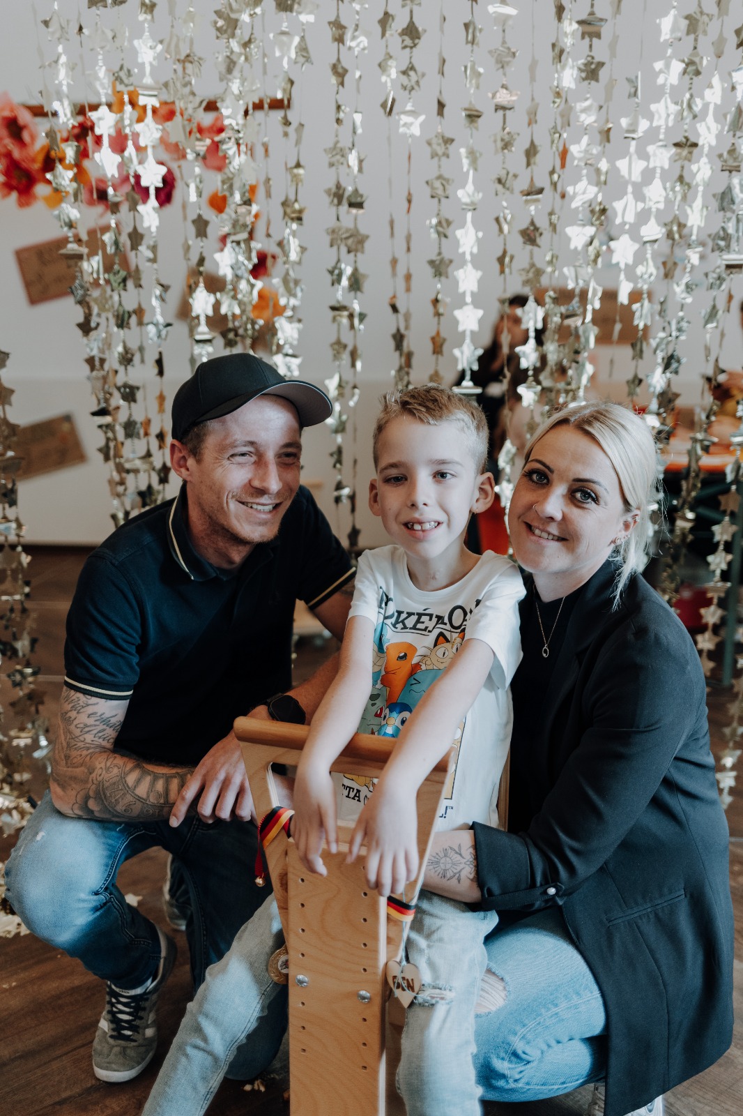 Ein Mann, ein Kind auf dem Holzwägelchen und die Mutter.